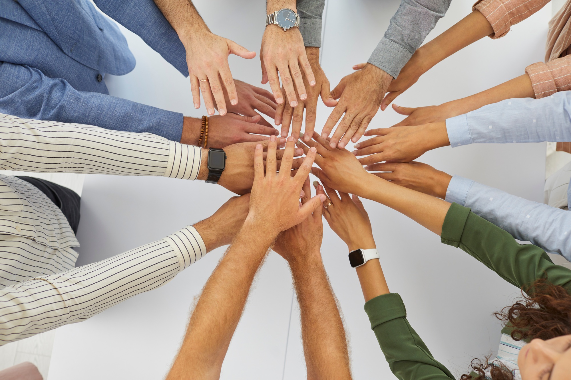 Team of business people who work together stacking their hands in a work meeting